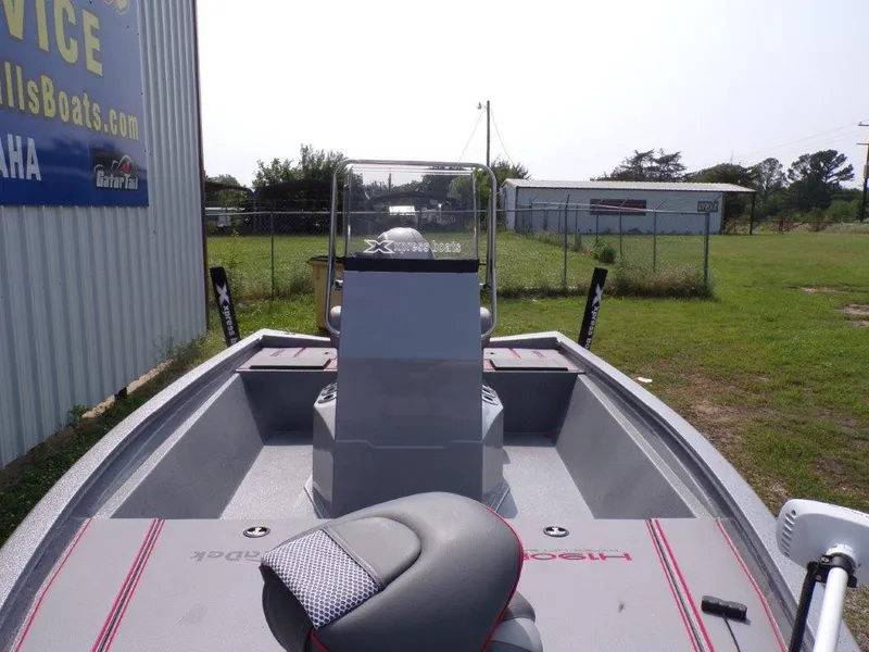 Slide: The Image of 2024 Xpress H190Bay boat, interior view with console and seating, parked outdoors. - 4