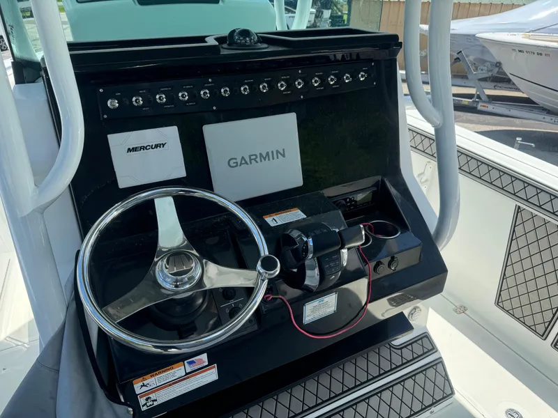 Slide: The Image of 2022 Wellcraft 262 Fisherman boat dashboard with Garmin and Mercury controls. - 16