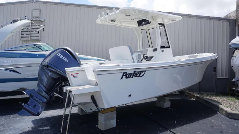 Slide: The Image of 2025 Parker 2400 CC boat with Yamaha outboard motor in a storage yard. - 1