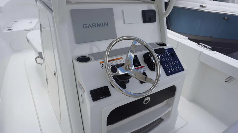 Slide: The Image of 2025 Parker 2400 CC boat console with Garmin navigation system and steering wheel. - 11