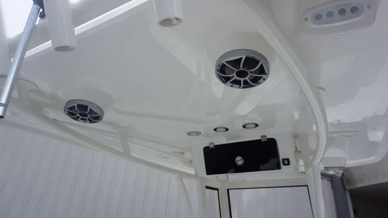 Slide: The Image of Parker 2400 CC 2025 boat interior ceiling with speakers and rod holders. - 13