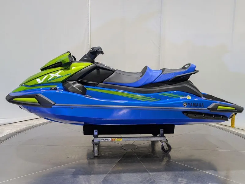 Slide: The Image of 2024 Yamaha Boats VX® Limited HO in vibrant blue and green, side view. - 31