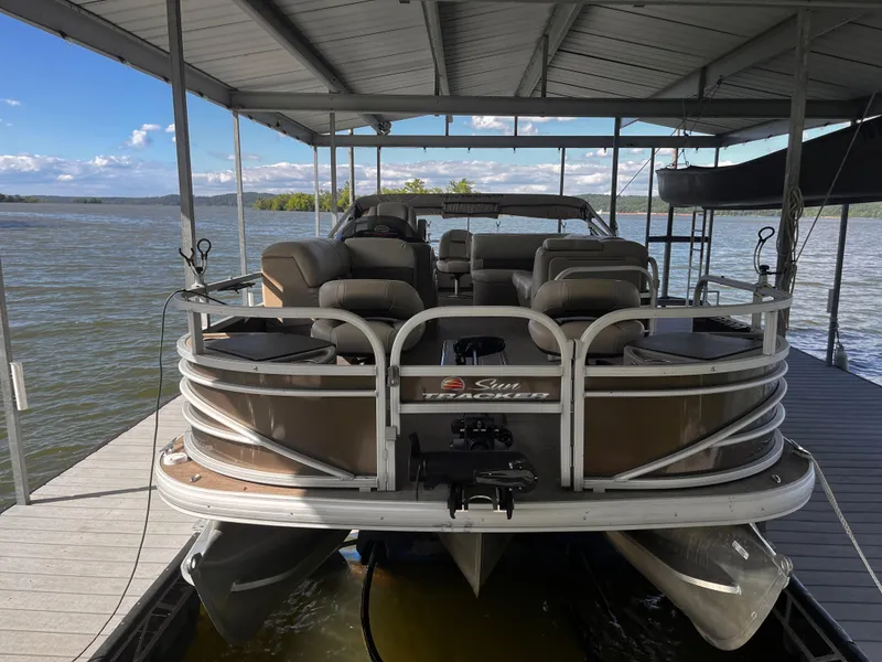 Slide: The Image of 2019 Sun Tracker Fishin' Barge 24 DLX pontoon boat docked under a covered slip. - 18