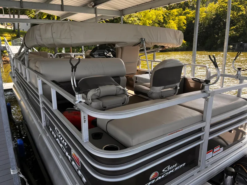 Slide: The Image of 2019 Sun Tracker Fishin' Barge 24 DLX pontoon boat docked under a covered slip. - 20