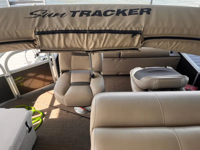 Slide: The Image of 2019 Sun Tracker Fishin' Barge 24 DLX interior with beige seating and canopy. - 34