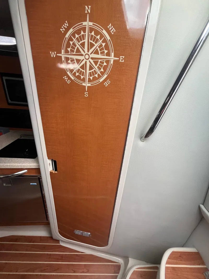 Slide: The Image of 2007 Chaparral Signature 280 cabin interior with compass design on wooden door. - 16