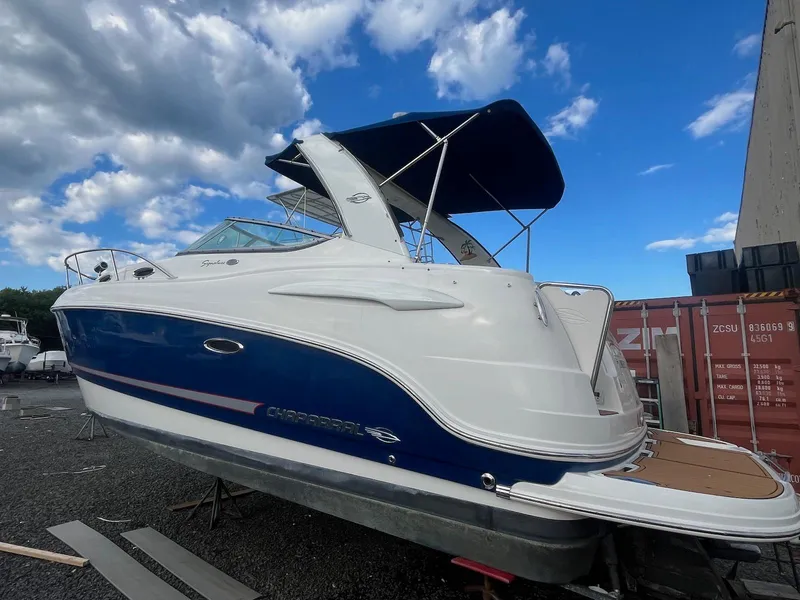 Slide: The Image of 2007 Chaparral Signature 280 boat with blue and white exterior, docked under a blue sky. - 2