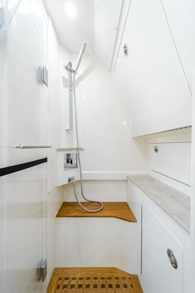 Slide: The Image of 2020 Scout 420 LXF boat interior shower with modern fixtures and wooden accents. - 11