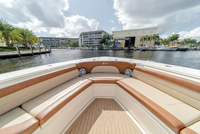 Slide: The Image of 2020 Scout 420 LXF boat with luxurious seating, docked near waterfront buildings. - 33