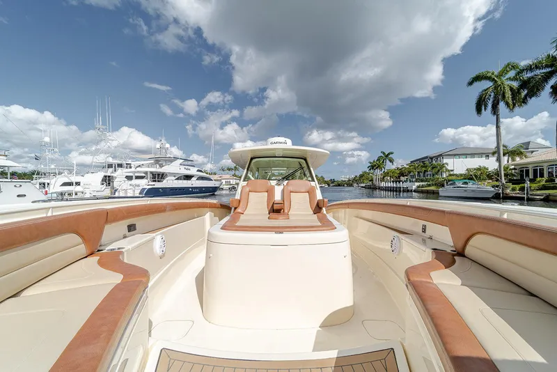 Slide: The Image of 2020 Scout 420 LXF luxury boat with spacious seating, docked under a partly cloudy sky. - 37