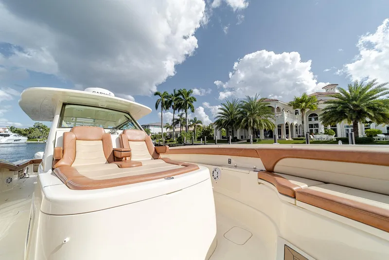 Slide: The Image of 2020 Scout 420 LXF boat with luxurious seating, docked near waterfront mansion. - 38