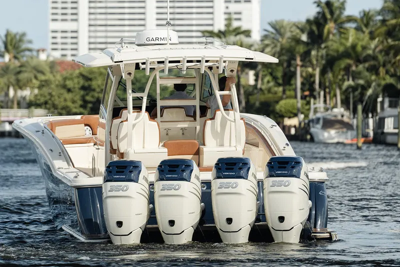 Slide: The Image of 2020 Scout 420 LXF boat with four powerful engines cruising on a scenic waterway. - 4