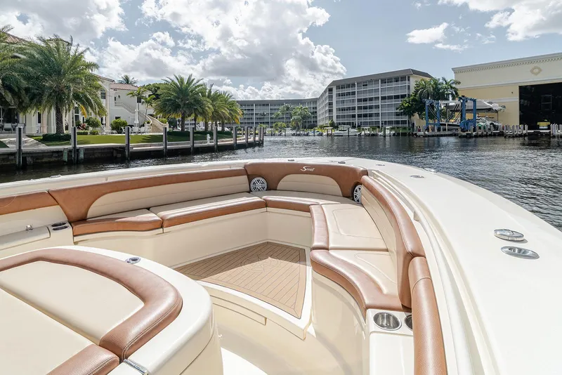 Slide: The Image of 2020 Scout 420 LXF boat with luxurious seating, docked near waterfront buildings and palm trees. - 40