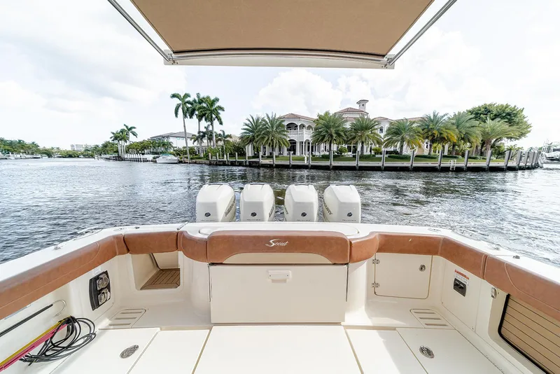 Slide: The Image of 2020 Scout 420 LXF boat with luxurious seating, overlooking waterfront mansion and palm trees. - 43