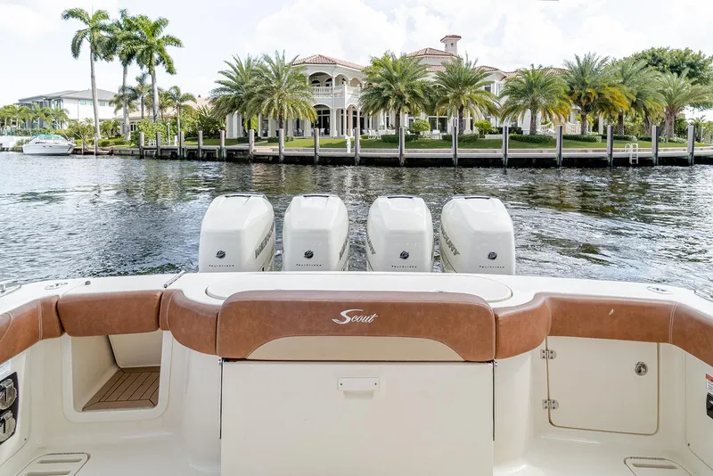 Slide: The Image of 2020 Scout 420 LXF boat with four engines, docked near waterfront mansion and palm trees. - 44