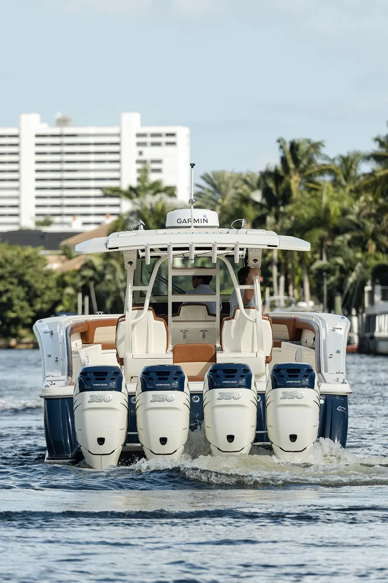 Slide: The Image of 2020 Scout 420 LXF boat with four engines cruising on water, cityscape background. - 5