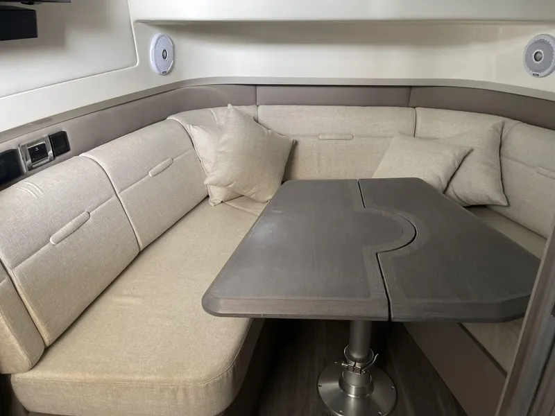 Slide: The Image of 2022 Sea Ray SLX 400 interior with beige seating and a wooden table. - 14
