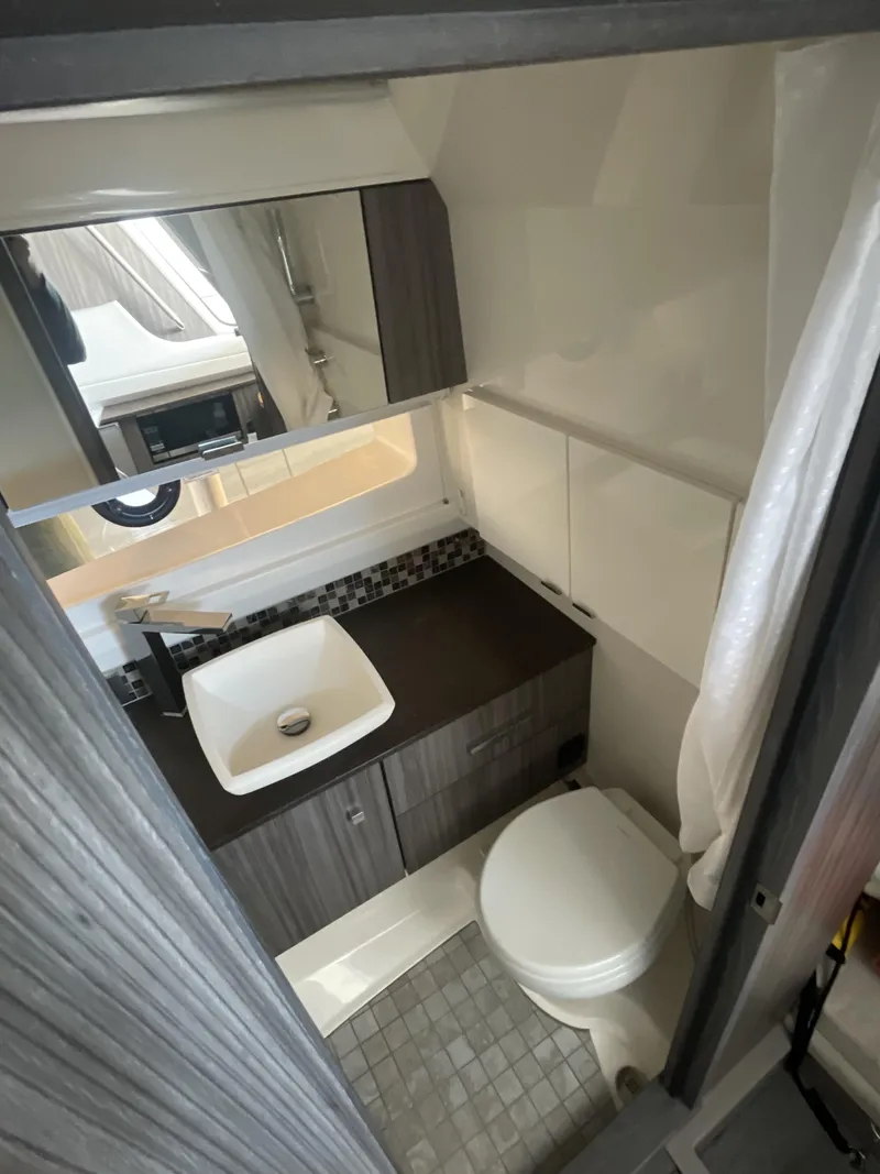 Slide: The Image of 2022 Sea Ray SLX 400 bathroom with modern sink, toilet, and sleek cabinetry. - 8