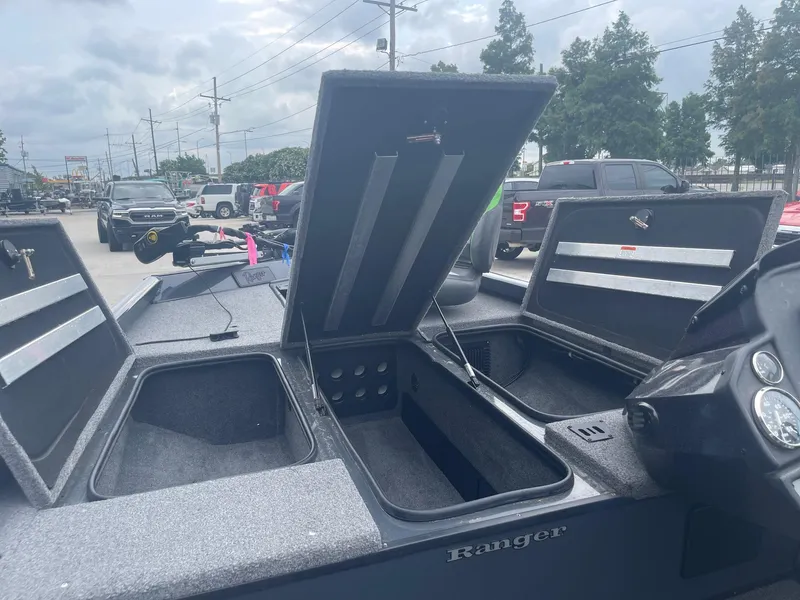 Slide: The Image of 2022 Ranger RT188 boat with open storage compartments in a parking lot. - 12
