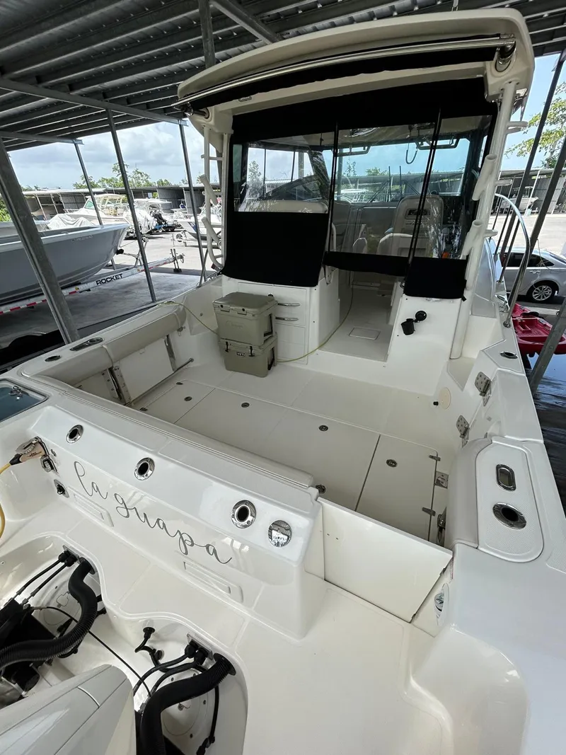 Slide: The Image of 2022 Boston Whaler 325 Conquest boat docked under a covered marina. - 4