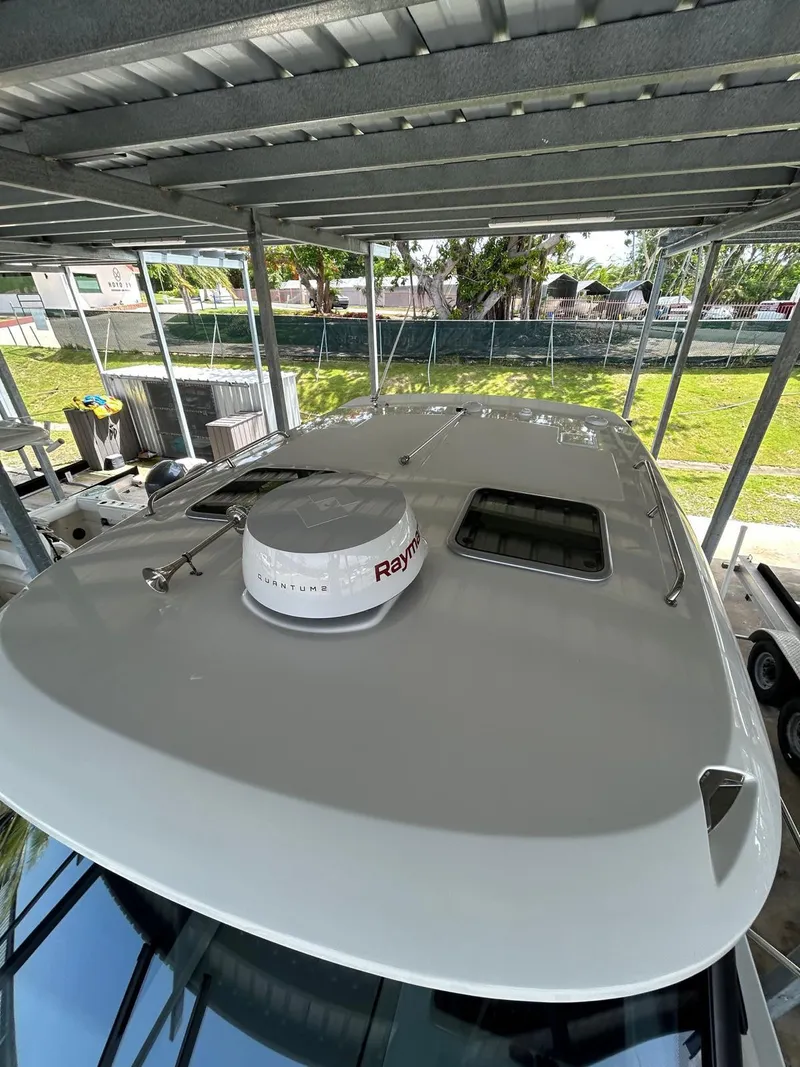 Slide: The Image of 2022 Boston Whaler 325 Conquest boat under shelter, featuring Raymarine radar. - 6