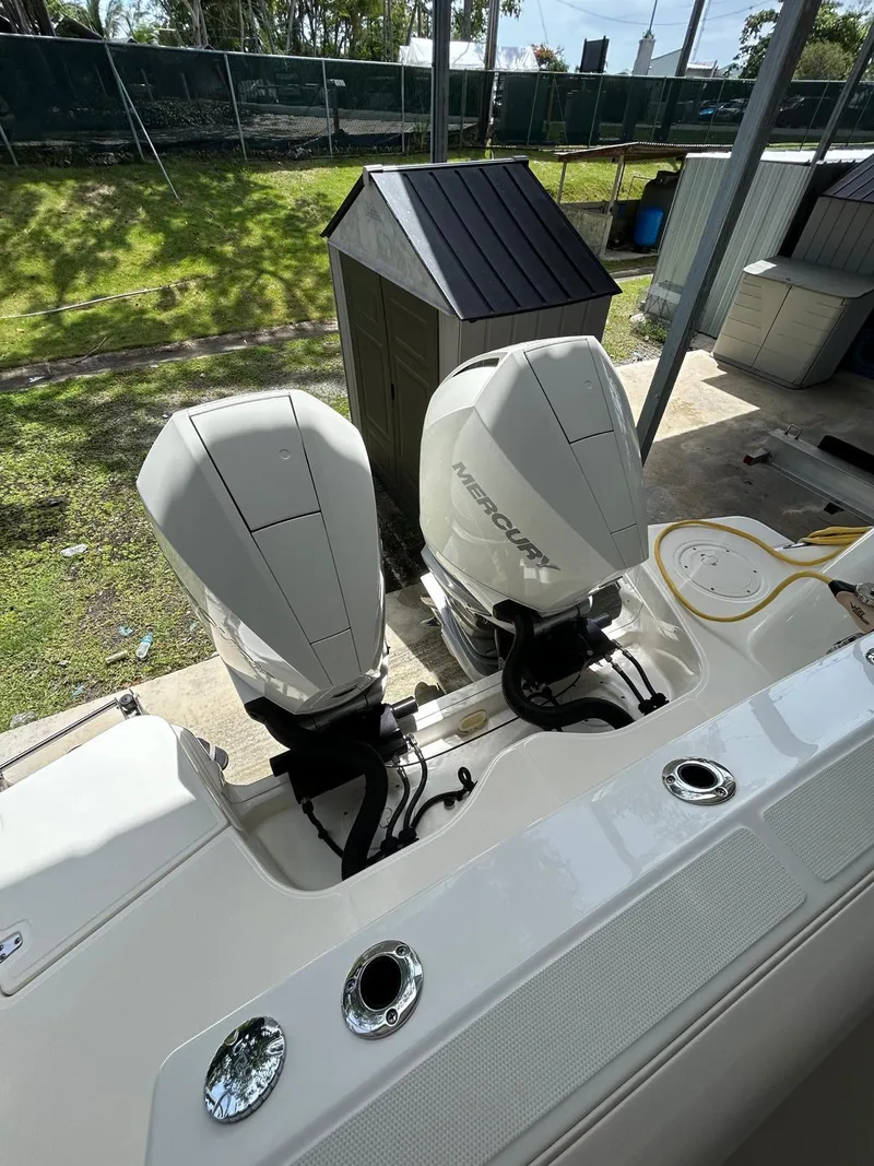 Slide: The Image of 2022 Boston Whaler 325 Conquest with dual Mercury outboard engines, docked outdoors. - 8