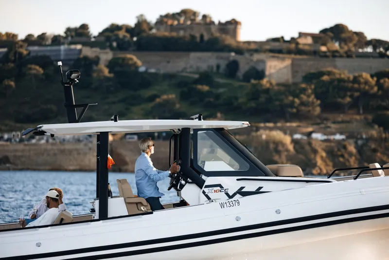Slide: The Image of 2025 Zodiac X10CC boat cruising near a scenic coastline. - 2