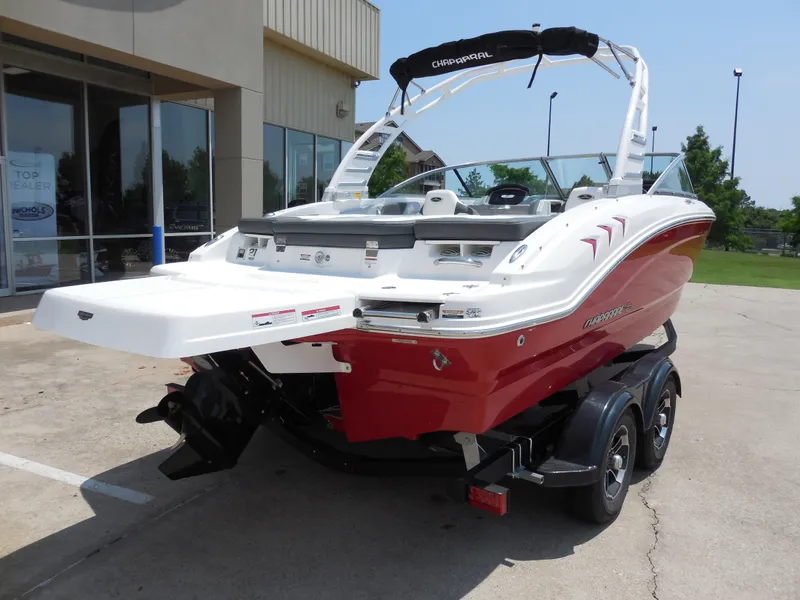 Slide: The Image of 2024 Chaparral 21 SSi boat with red hull on a trailer, rear view. - 3