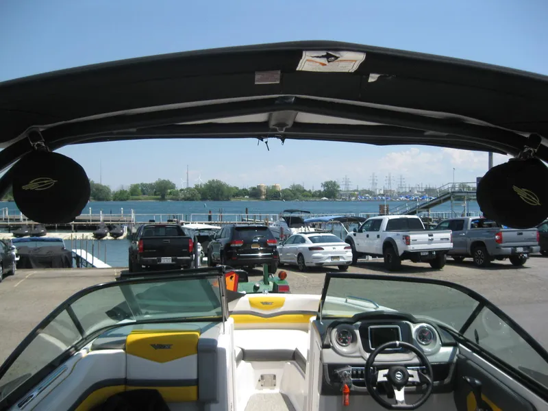 Slide: The Image of 2015 Chaparral 203 Vortex VRX boat at a marina with parked cars. - 9
