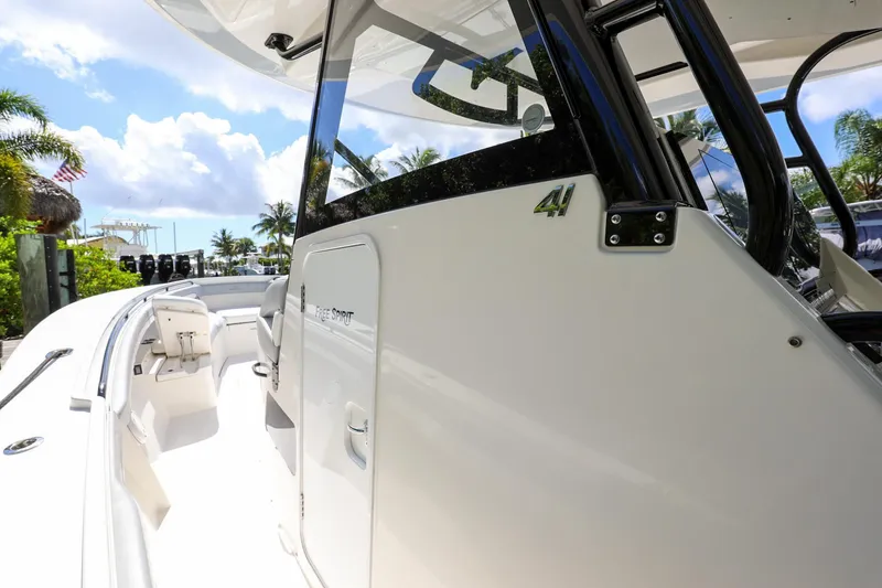 Slide: The Image of 2020 Regulator 41 boat, side view with cockpit and seating area, docked under sunny skies. - 24