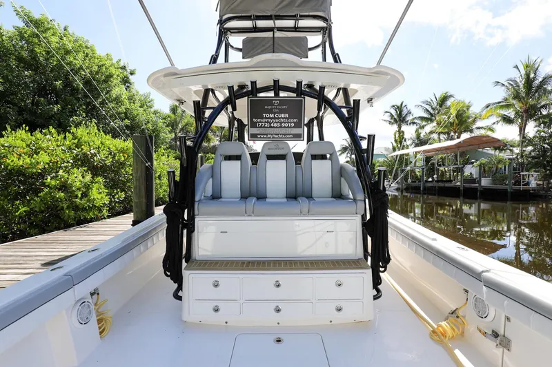 Slide: The Image of 2020 Regulator 41 boat interior with seating and storage, docked by a lush, tropical canal. - 9