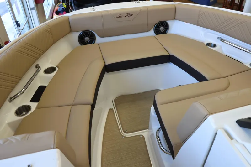 Slide: The Image of 2025 Sea Ray 250SDX boat interior with beige seating and cup holders. - 13