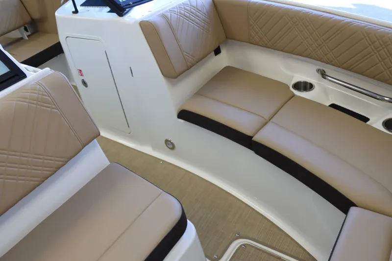 Slide: The Image of Luxurious seating area on 2025 Sea Ray 250SDX boat with beige upholstery and cup holders. - 15