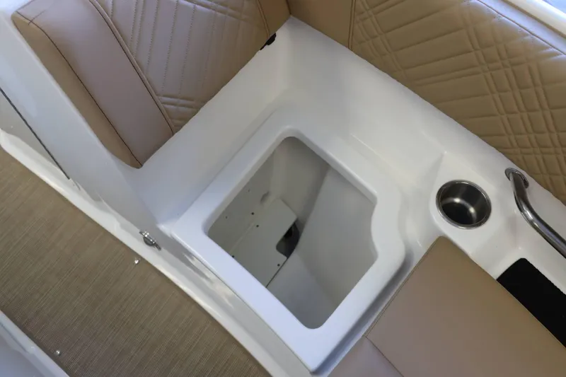 Slide: The Image of 2025 Sea Ray 250SDX boat interior with tan seating and storage compartment. - 17