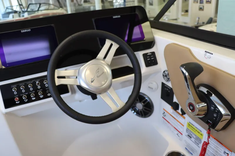 Slide: The Image of 2025 Sea Ray 250SDX helm with steering wheel and control panel. - 26