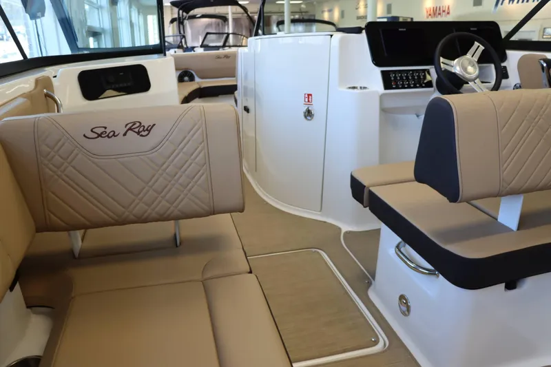 Slide: The Image of 2025 Sea Ray 250SDX boat interior with beige seating and modern dashboard. - 29