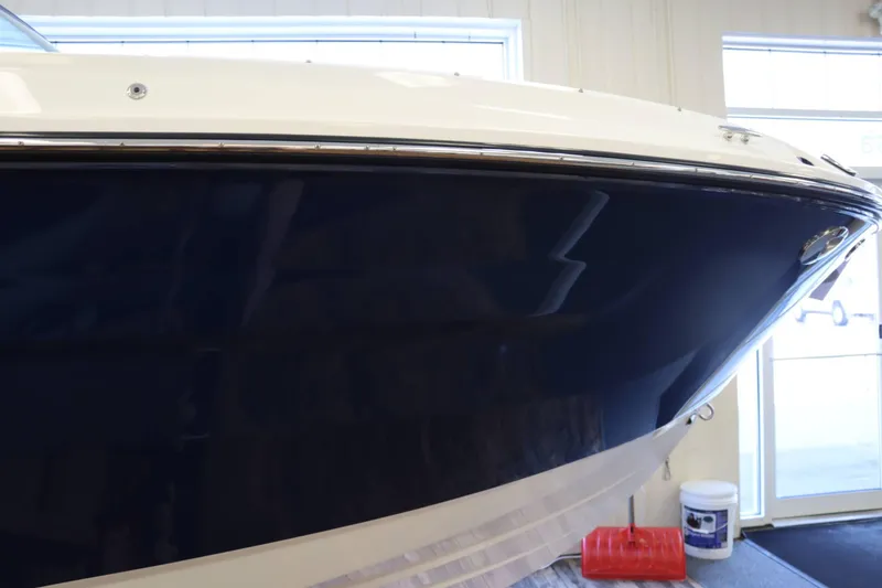 Slide: The Image of 2025 Sea Ray 250SDX boat in showroom, featuring sleek blue hull design. - 3