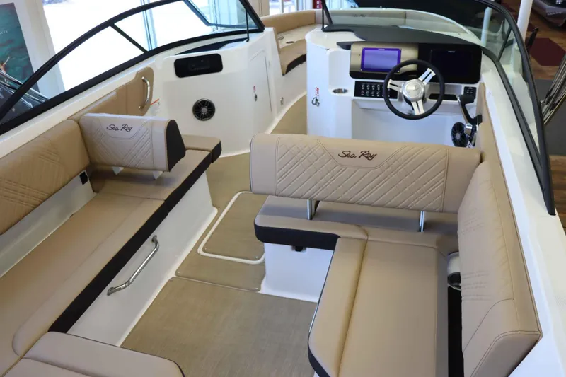 Slide: The Image of 2025 Sea Ray 250SDX boat interior with beige seating and modern dashboard. - 30