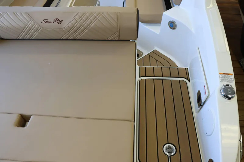 Slide: The Image of 2025 Sea Ray 250SDX boat interior with tan seating and wood-style flooring. - 34