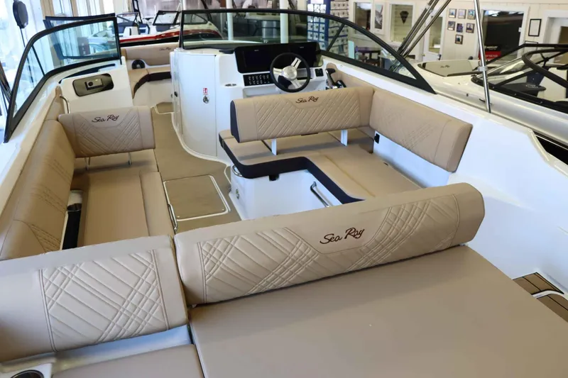Slide: The Image of 2025 Sea Ray 250SDX boat interior with beige seating and modern dashboard. - 35
