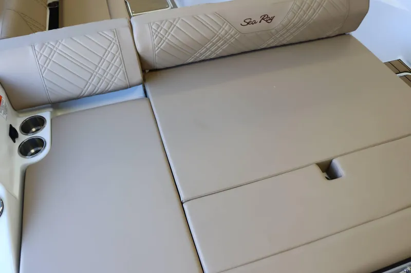 Slide: The Image of 2025 Sea Ray 250SDX boat interior with beige seating and cup holders. - 36