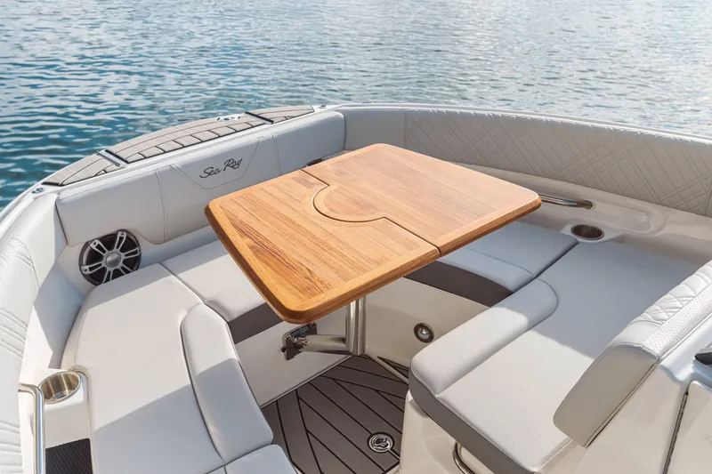 Slide: The Image of 2025 Sea Ray 250SDX boat interior with wooden table and cushioned seating. - 39