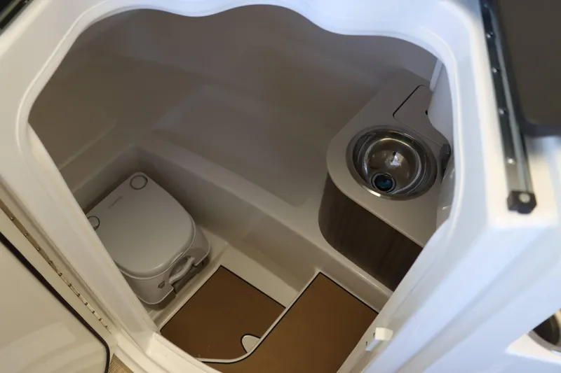 Slide: The Image of 2025 Sea Ray 250SDX boat interior with compact toilet and sink. - 9