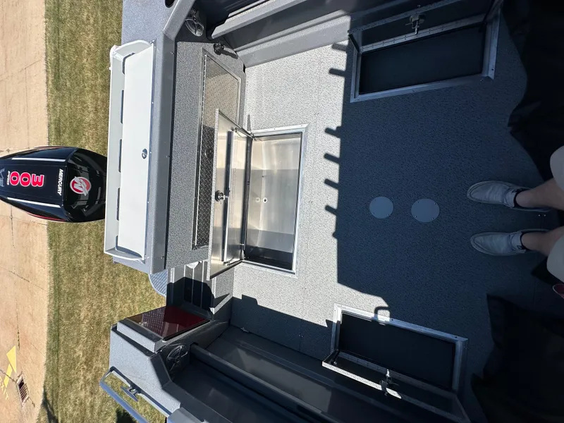 Slide: The Image of 2024 Spartan 220 Maximus boat interior with outboard motor, spacious deck, and storage compartments. - 15
