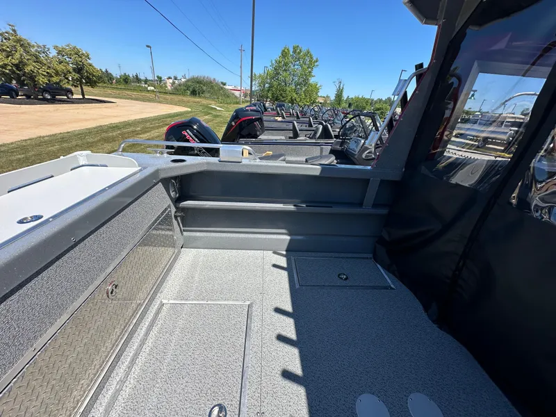 Slide: The Image of 2024 Spartan 220 Maximus boat interior with storage compartments and outboard motors. - 18