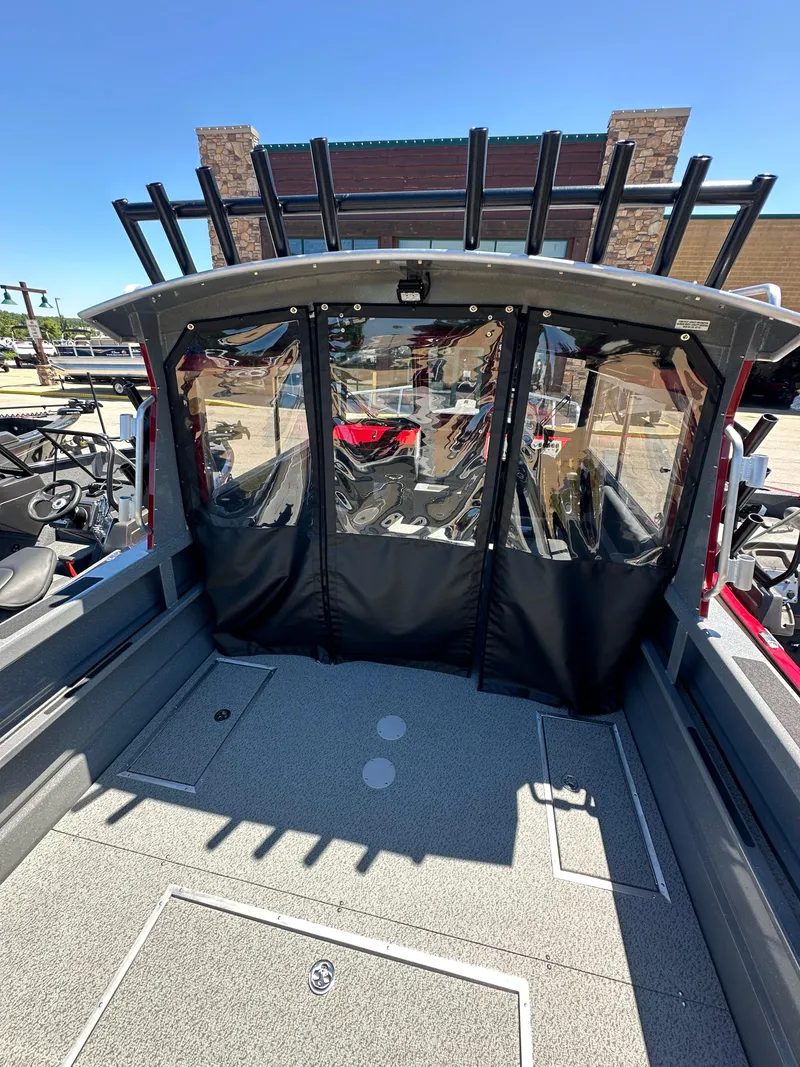 Slide: The Image of 2024 Spartan 220 Maximus boat interior with rod holders and covered cabin. - 21