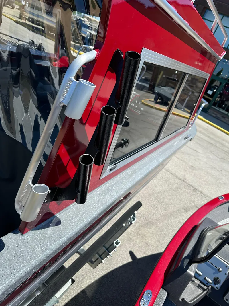 Slide: The Image of 2024 Spartan 220 Maximus boat with rod holders and red exterior. - 25