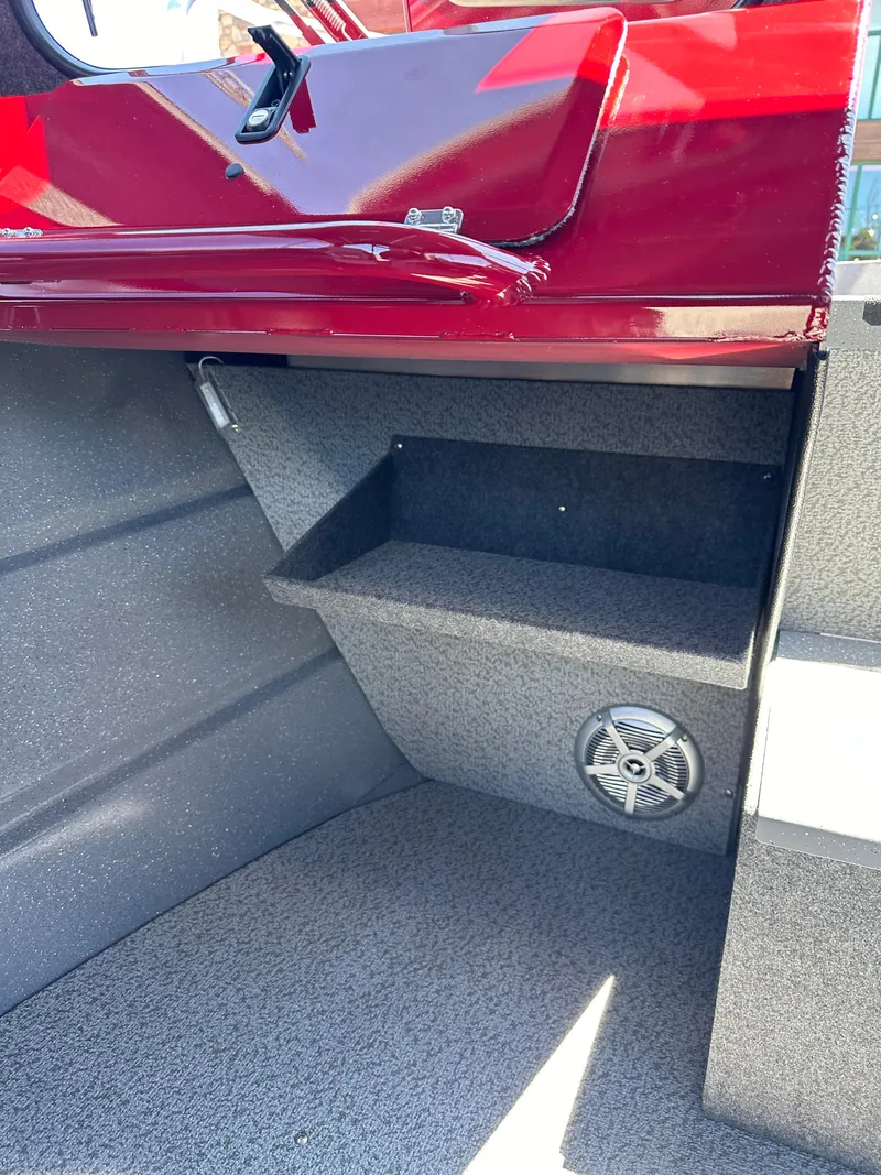 Slide: The Image of 2024 Spartan 220 Maximus boat interior with storage compartment and speaker. - 28