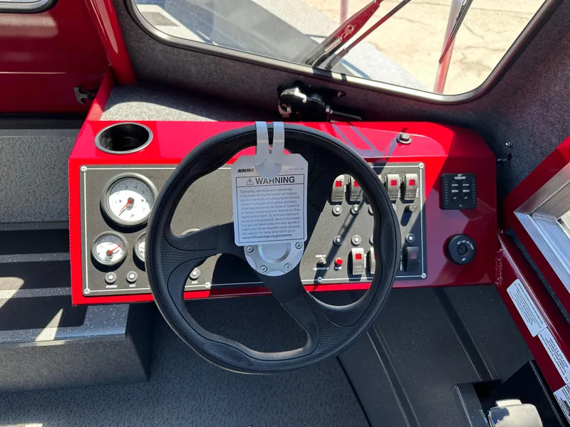 Slide: The Image of 2024 Spartan 220 Maximus boat dashboard with steering wheel and control panel. - 31
