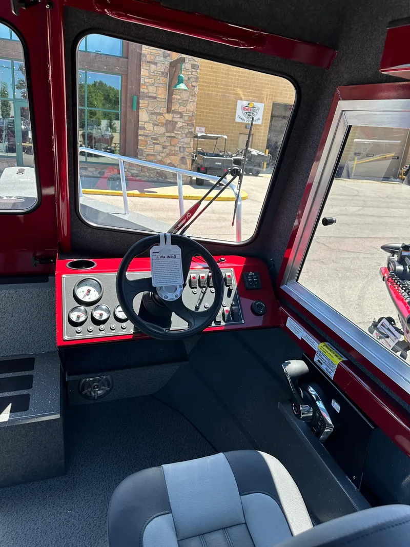 Slide: The Image of 2024 Spartan 220 Maximus boat cockpit with steering wheel and control panel. - 32